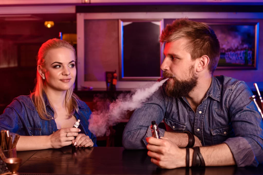 Man and Woman vaping at bar